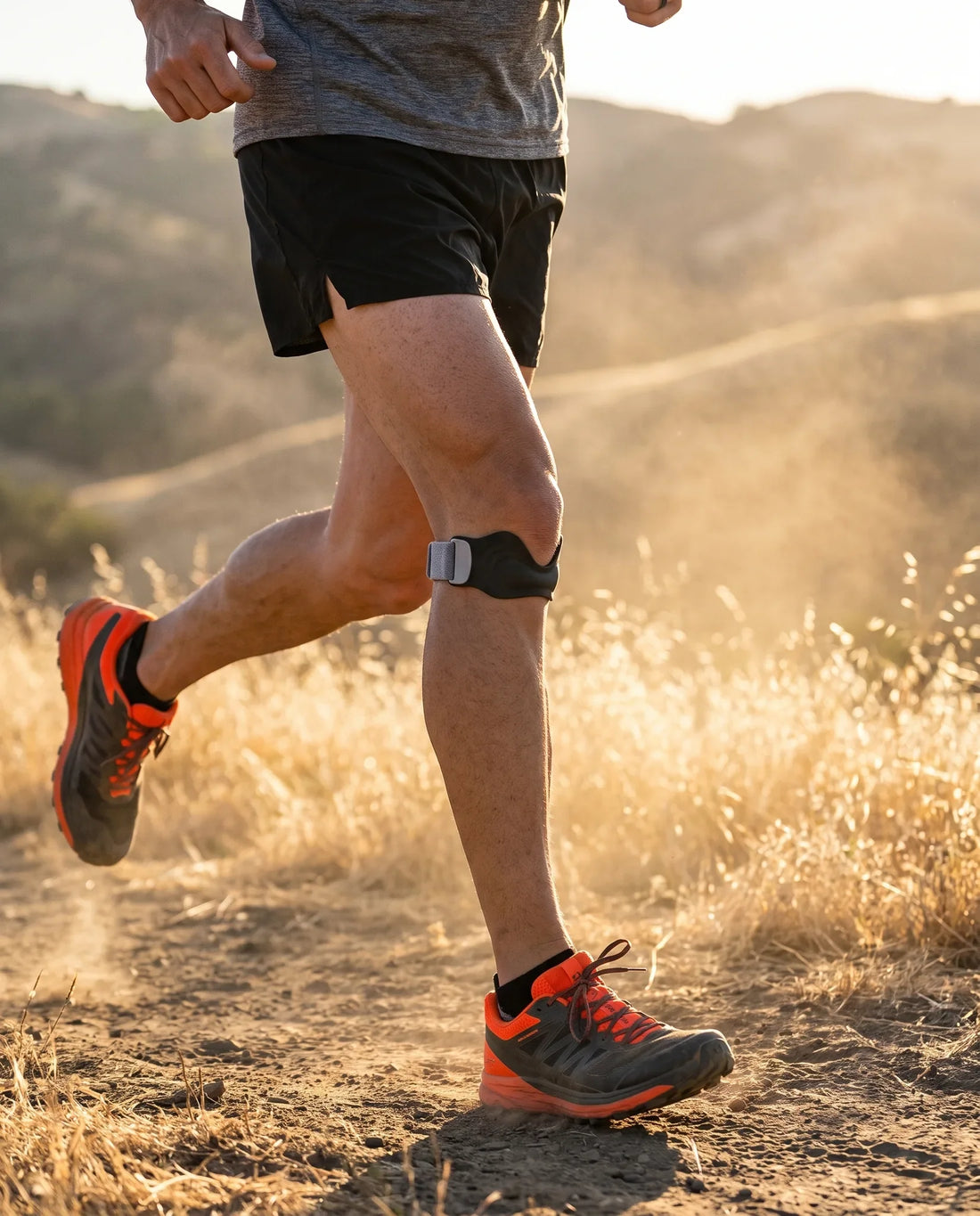 Runner on a trail wearing a knee strap for running below the kneecap