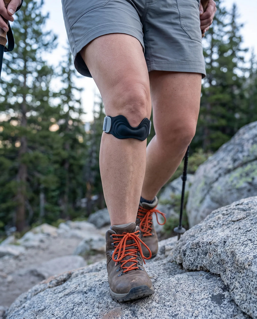Hiker heading downhill with a patella strap below the kneecap